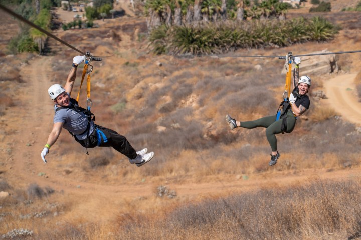 a man flying through the air while riding a bike down a dirt road